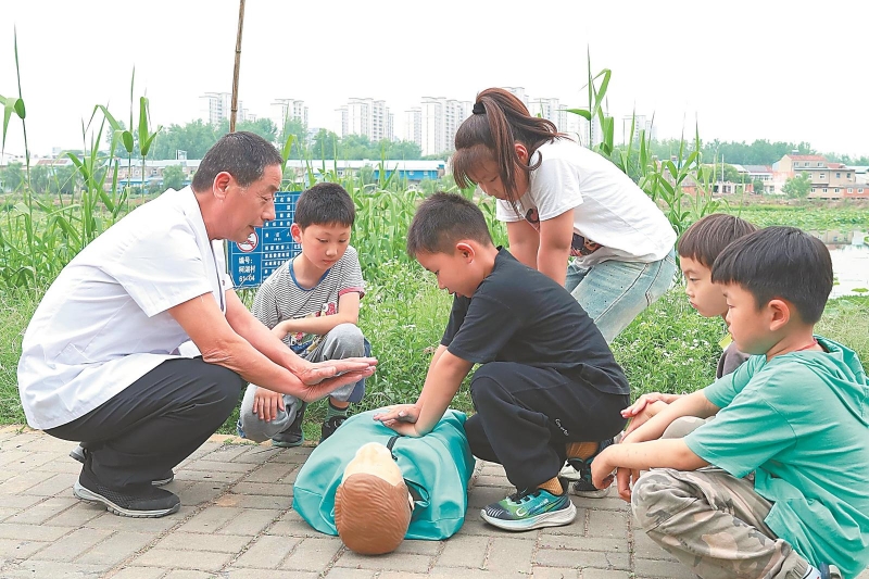 5月14日,滁州市南谯区乌衣镇柯湖村,医务志愿者在为小朋友讲解防溺水急救知识。志愿者通过“场景化教学+沉浸式体验”的方式,进一步增强未成年人防溺水安全意识。.jpg